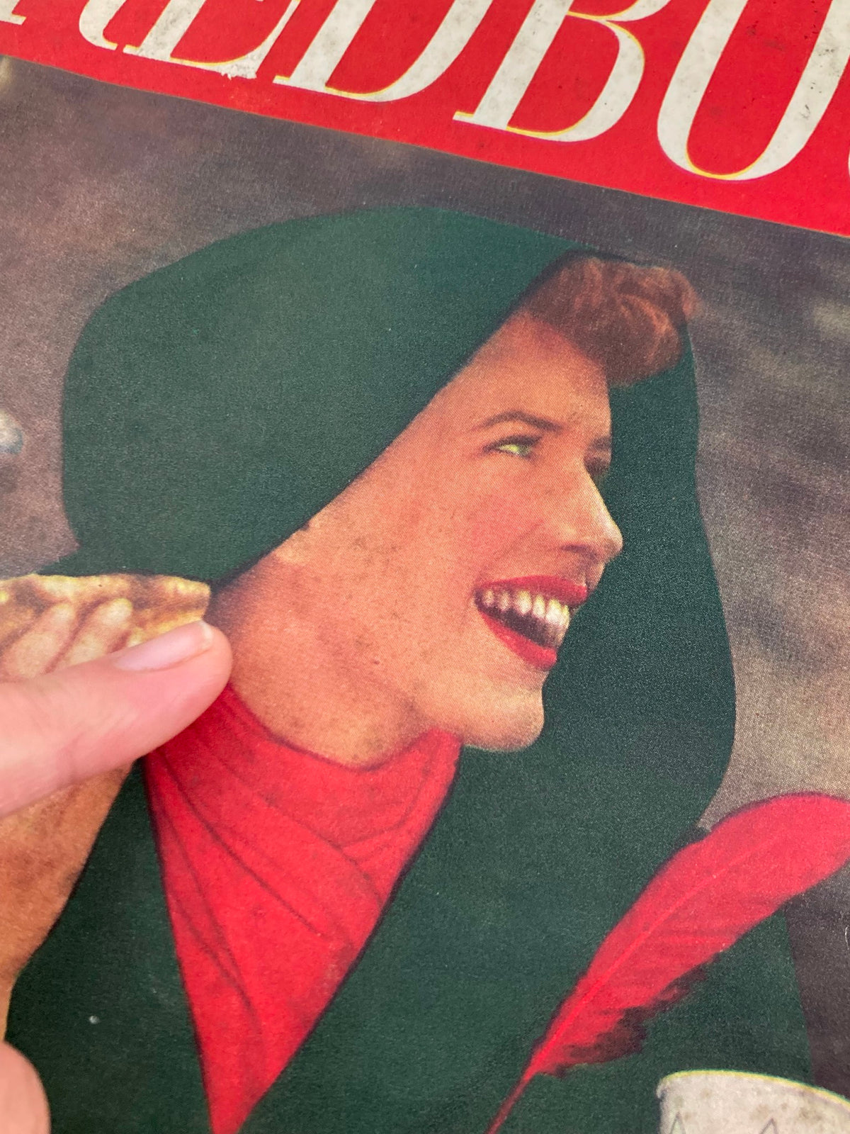 Close-up of a woman on the VTG Redbook Magazine October 1947 cover, smiling and enjoying a snack.