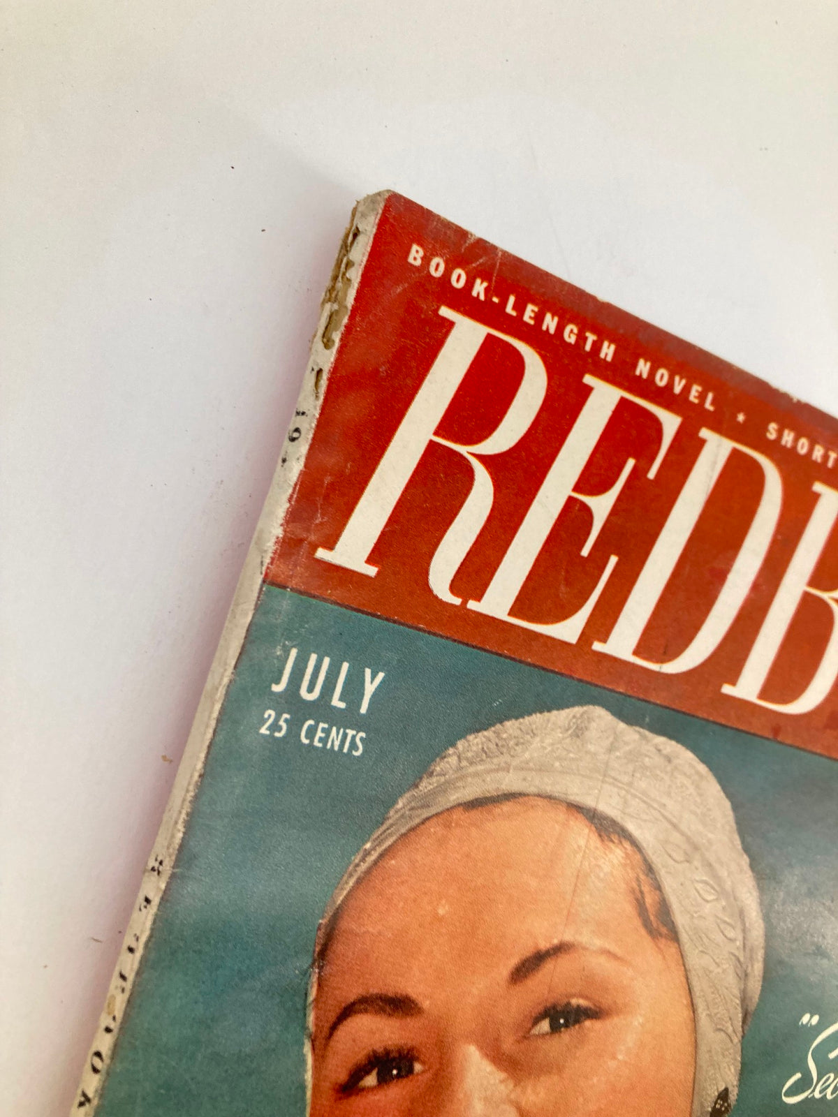 Close-up of VTG Redbook Magazine July 1948, showing the cover with the title and a woman's portrait, highlighting the vintage design and authentic features.