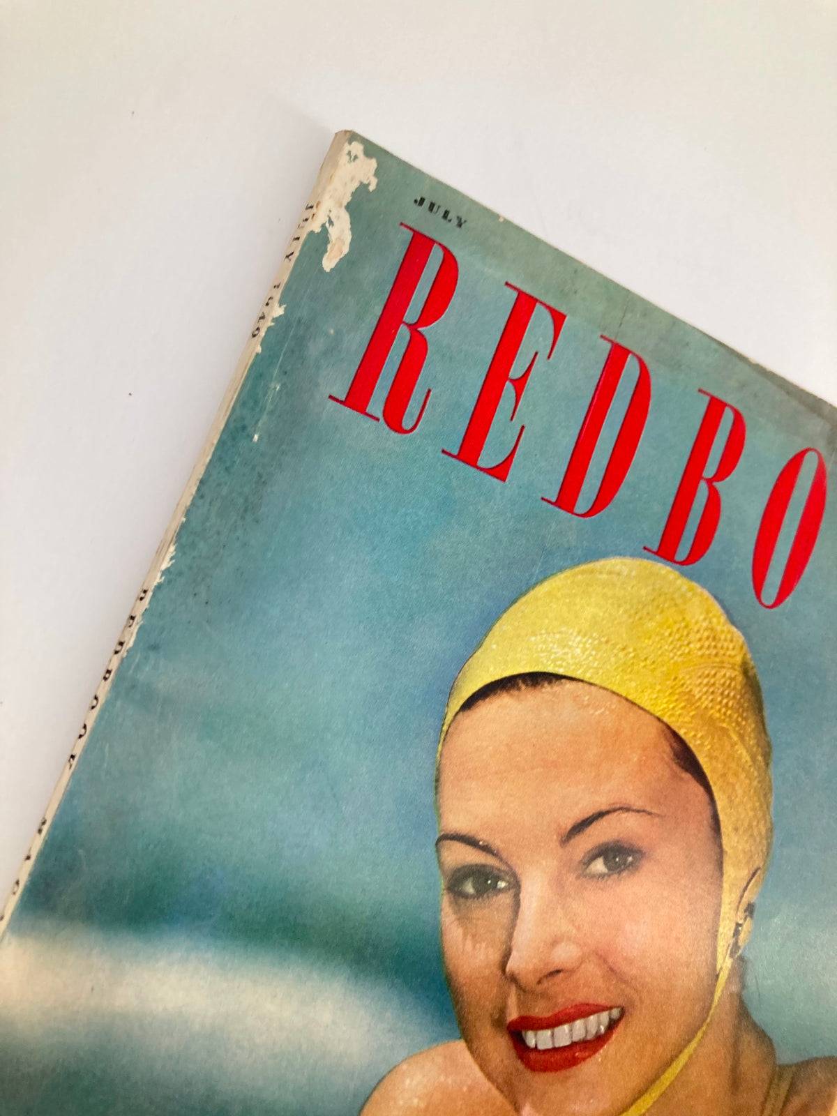 Close-up of the VTG Redbook Magazine from July 1949 Vol 93 #3 showing details of the cover with a woman in a yellow swim cap and the magazine title in bold red letters.
