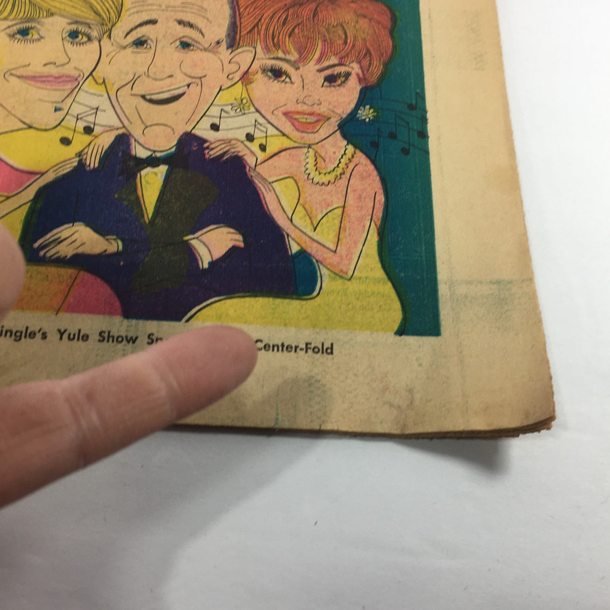 Close-up of the cover of VTG TV Week's Complete TV Listings December 13-20 1969, highlighting cartoon characters of a smiling man and two women with musical notes, associated with Der Bingle's Yule Show.