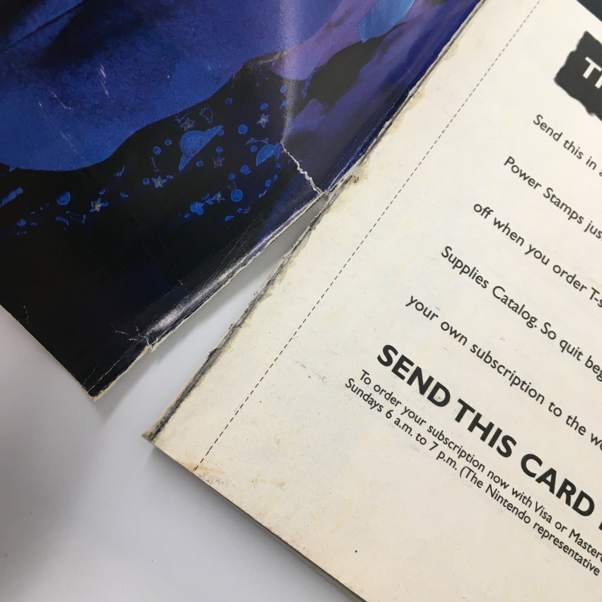 Close-up of a worn edge from the Nintendo Power Magazine May 1995 #72, highlighting minor rips and the magazine's binding damage.