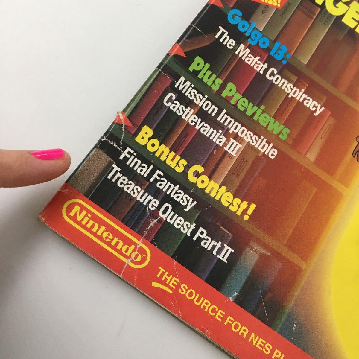 Close-up of the spine and cover highlights from Nintendo Power Magazine July 1990 featuring a finger pointing to sections including Chip 'N Dale Rescue Rangers, and a Bonus Contest, showcasing Nintendo's influence in gaming.