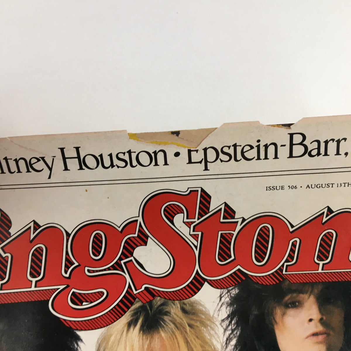 Close-up of the top section of the Rolling Stone Magazine dated August 13, 1987, featuring the title prominently along with the names Whitney Houston and Epstein-Barr. The magazine displays signs of wear, indicative of its vintage status.