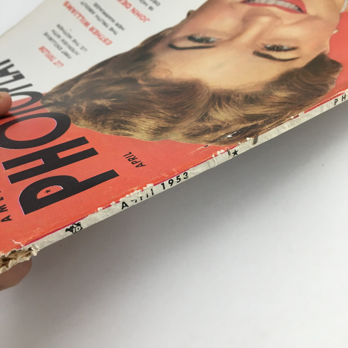 Side view of the spine of Photoplay Magazine, April 1953, highlighting wear and age. Represents the magazine's vintage condition, adding character to this piece of cinematic history.