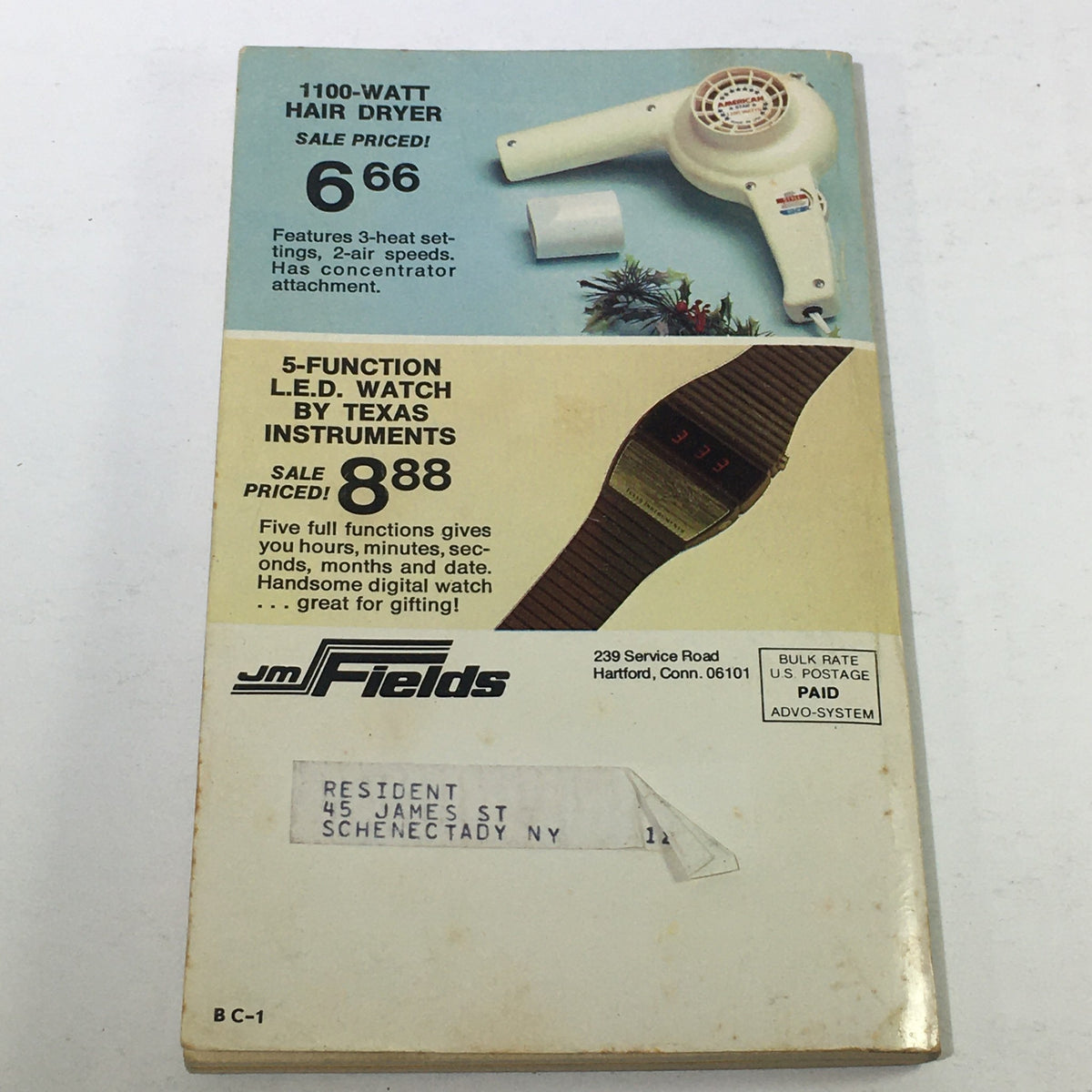 Back cover of the Vintage JM Fields The Christmas Sale Price Guide Catalog displaying a 1100-watt hair dryer and a 5-function L.E.D. watch with pricing, reflecting 1970s consumer goods.