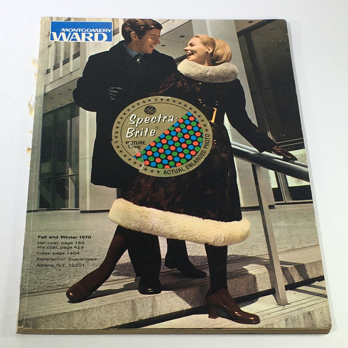 Cover of the VTG Montgomery Ward Price Guide Catalog Fall-Winter 1970 featuring a stylish couple, showcasing fashion trends of the era and the Spectra Brite sticker.