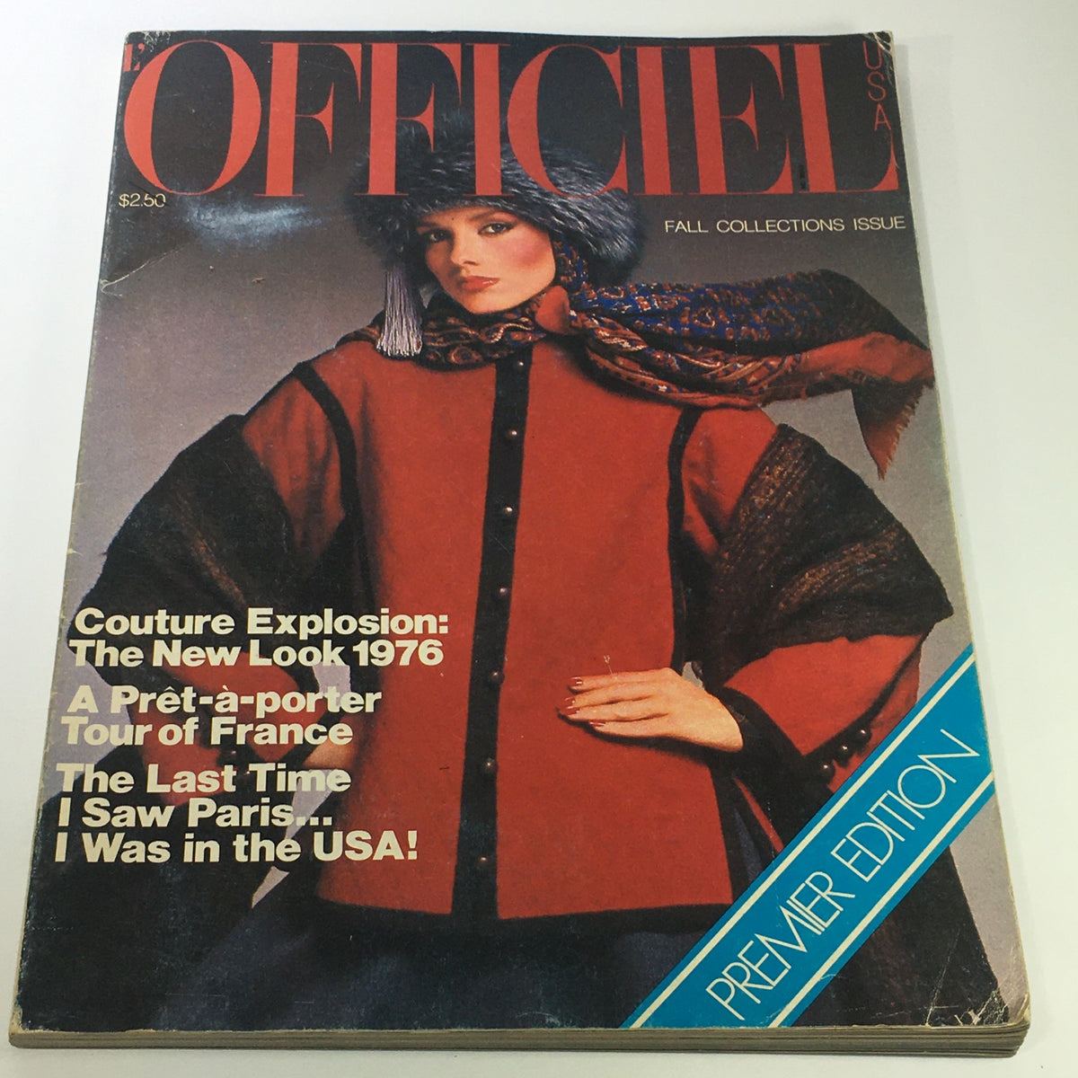 Cover of VTG L'Officiel USA Magazine Fall Collection Issue 1976 featuring a model in a striking red coat and fur hat, highlighting 1970s fashion.