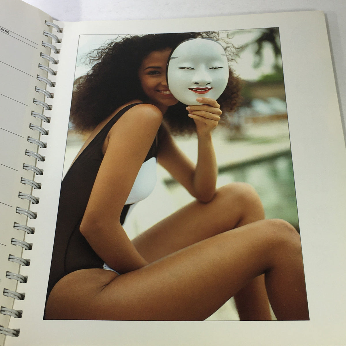 Page from the Sports Illustrated 1992 Swimsuit Desk Calendar with a model holding a mask, capturing a playful fashion moment.