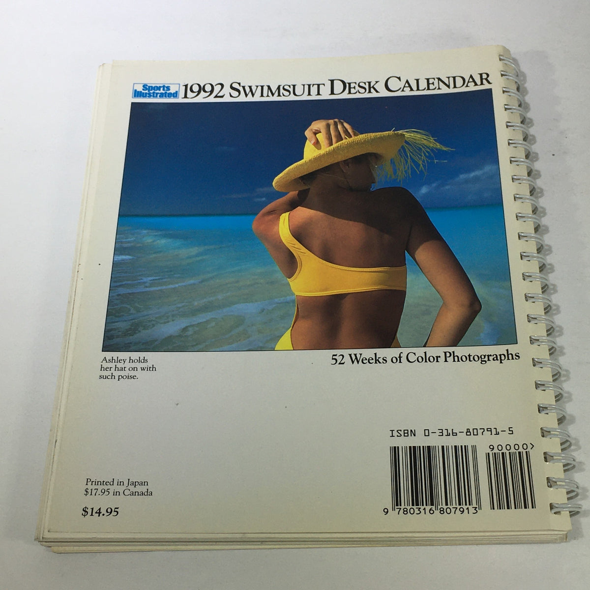 Sports Illustrated 1992 Swimsuit Desk Calendar back cover featuring a model in a yellow swimsuit and sun hat near the beach, emphasizing the calendar's vibrant photographic collection.