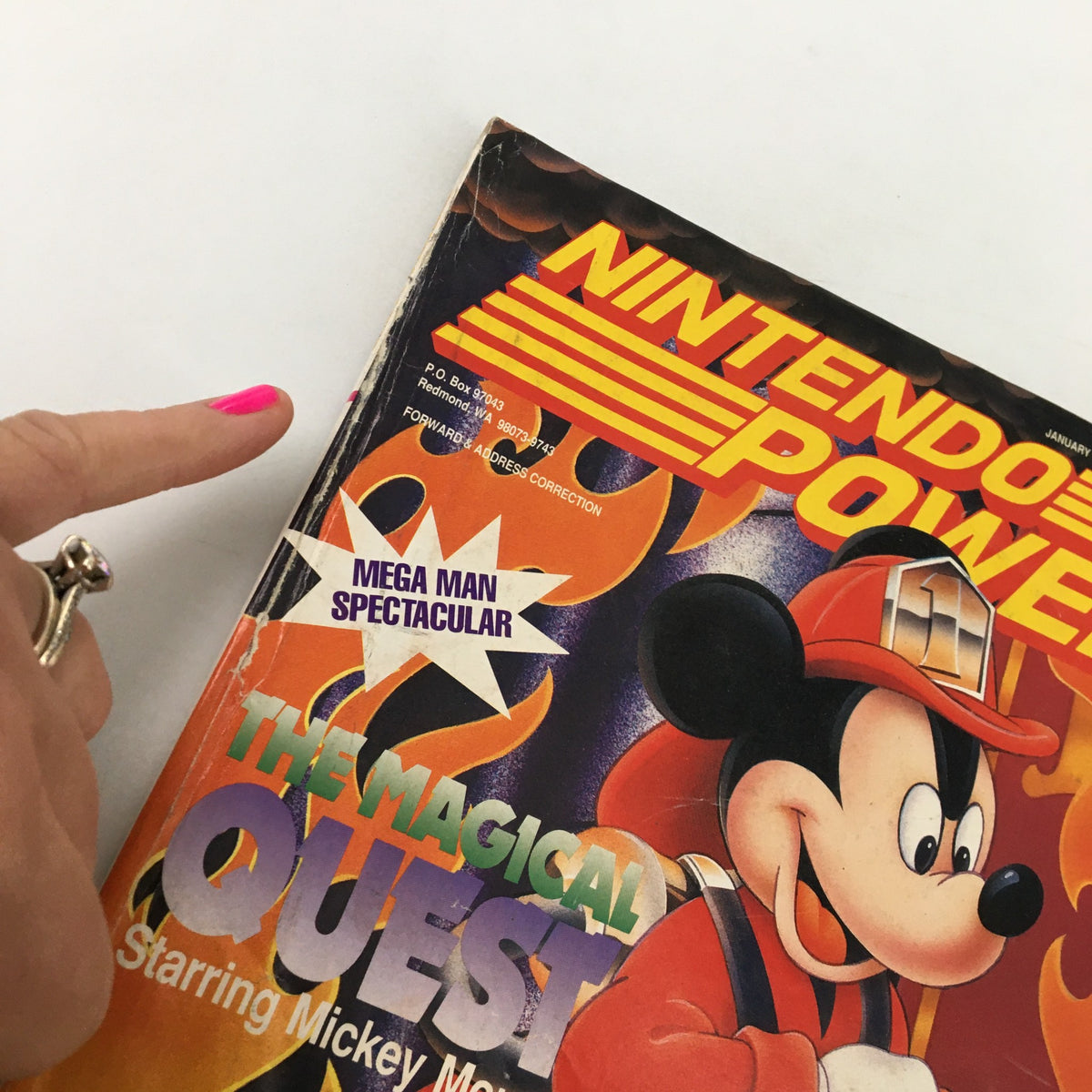 Close-up of the cover of Nintendo Power Magazine January 1993 #44, highlighting the 'Mega Man Spectacular' bullet point alongside Mickey Mouse's character in The Magical Quest.