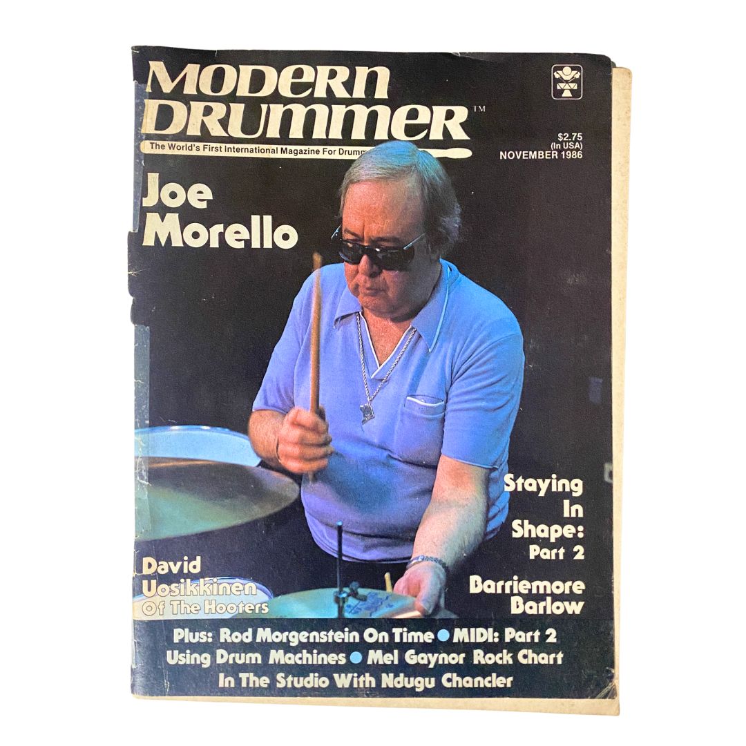 Cover of Modern Drummer Magazine November 1986 featuring drummer Joe Morello and David Uosikkinen of The Hooters. This vintage magazine highlights interviews and insights into the drumming scene of the 1980s.