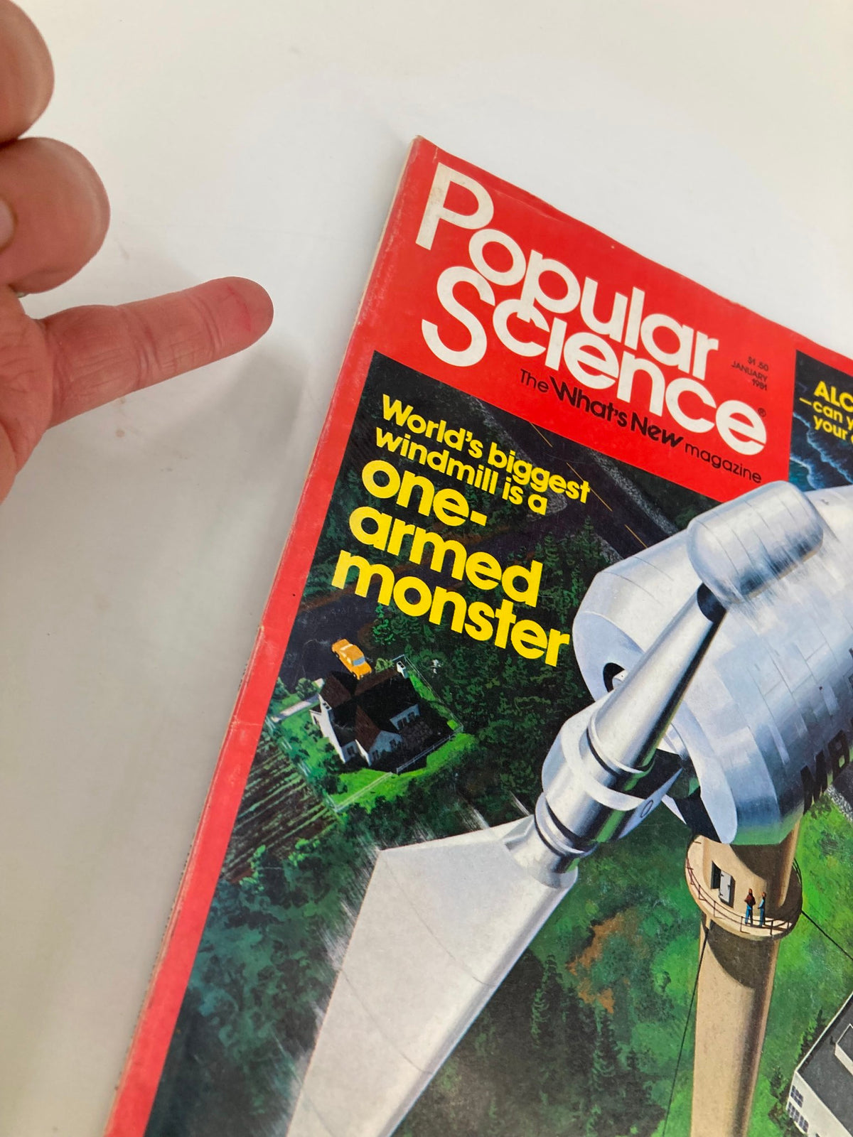 Angle view of the VTG Popular Science Magazine January 1981 cover emphasizing the headline "World's Biggest Windmill is a one-armed monster", with a person's finger pointing at the text.