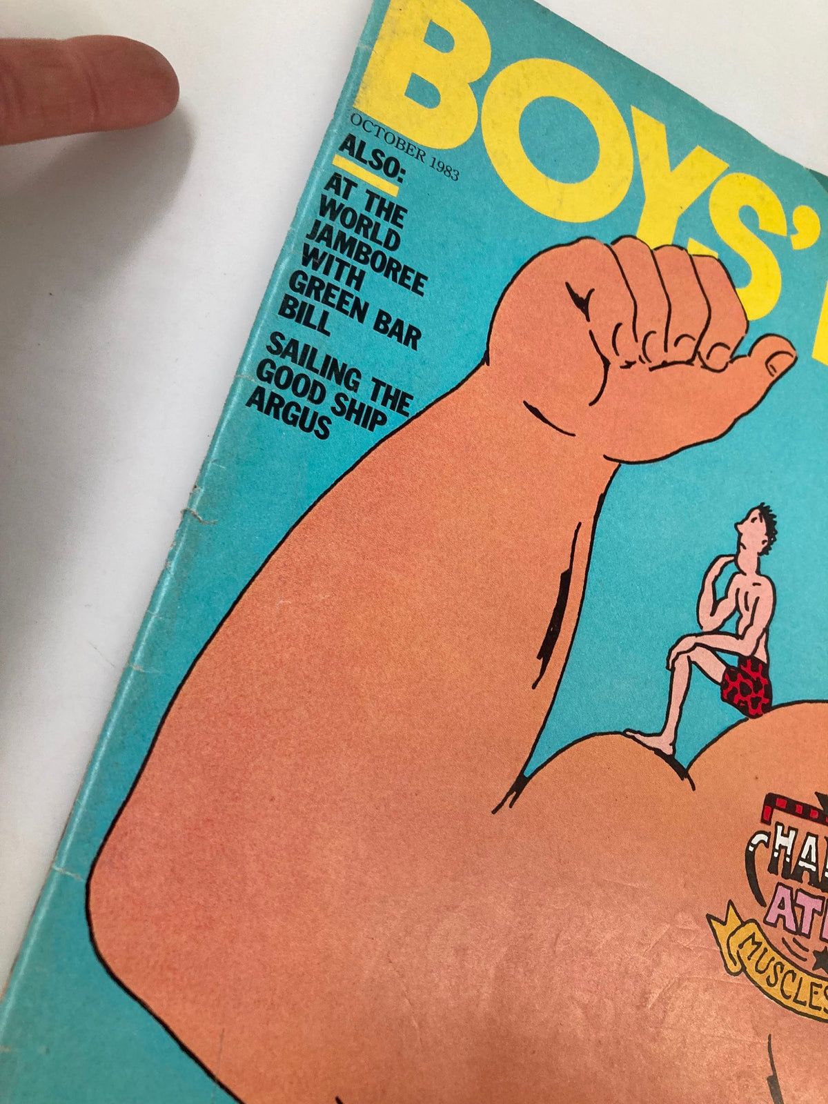 Side view of the Boys' Life Magazine October 1983 cover, highlighting the title and an illustration of a muscular figure alongside smaller imagery. This image emphasizes the magazine's vibrant retro style.