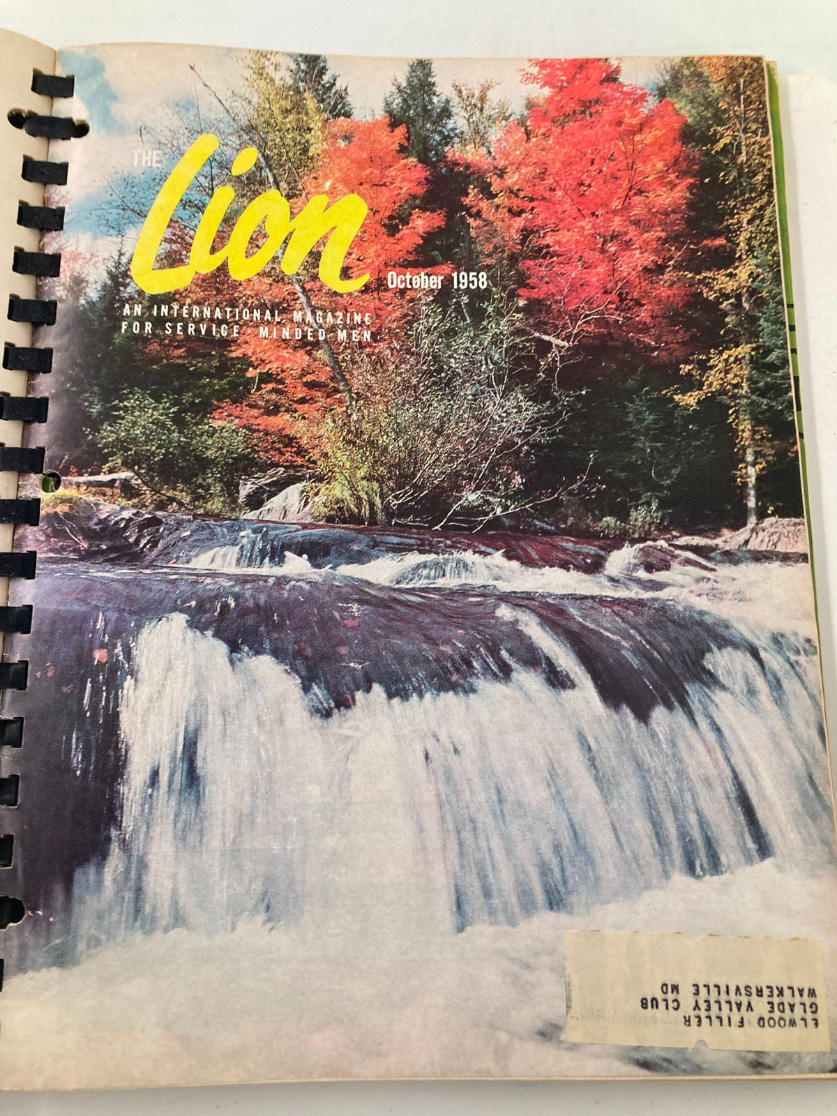 Cover of The Lion magazine, October 1958 edition, showcasing a beautiful autumn scene with vibrant red foliage and a serene waterfall.
