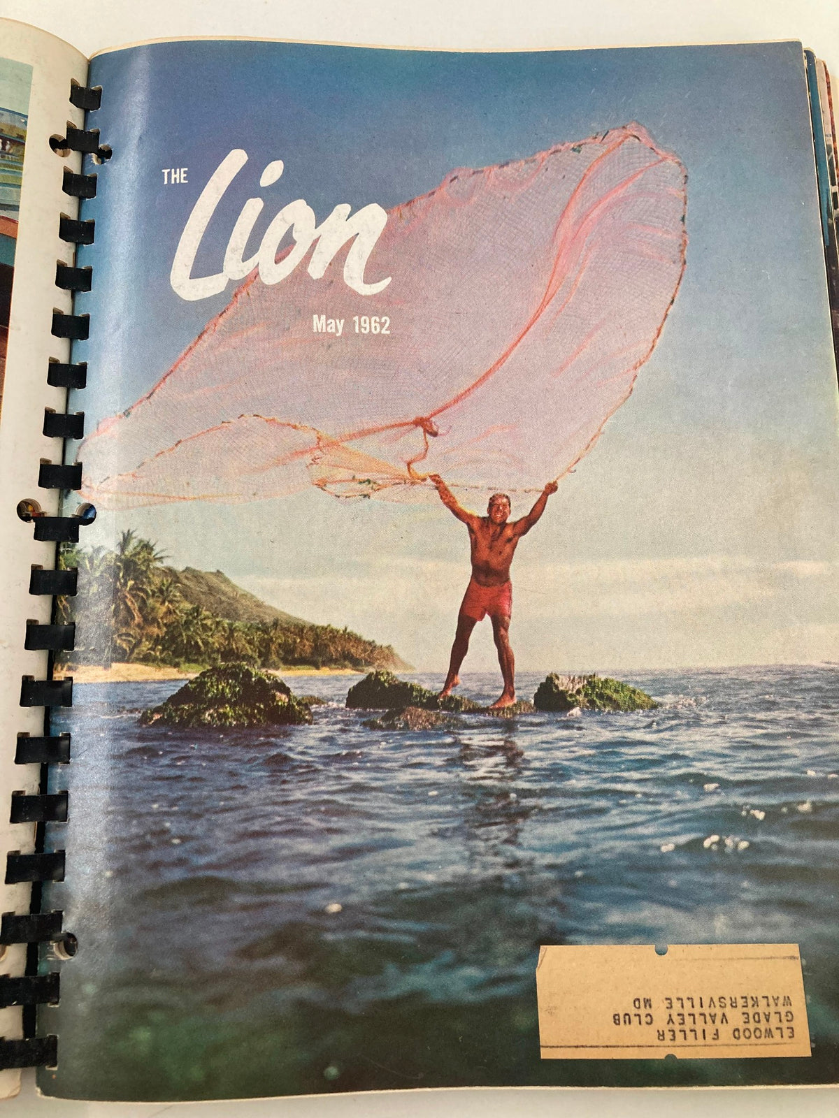 May 1962 cover of The Lion Magazine, depicting a man casting a fishing net on a rocky shore, highlighting themes of exploration and nature.