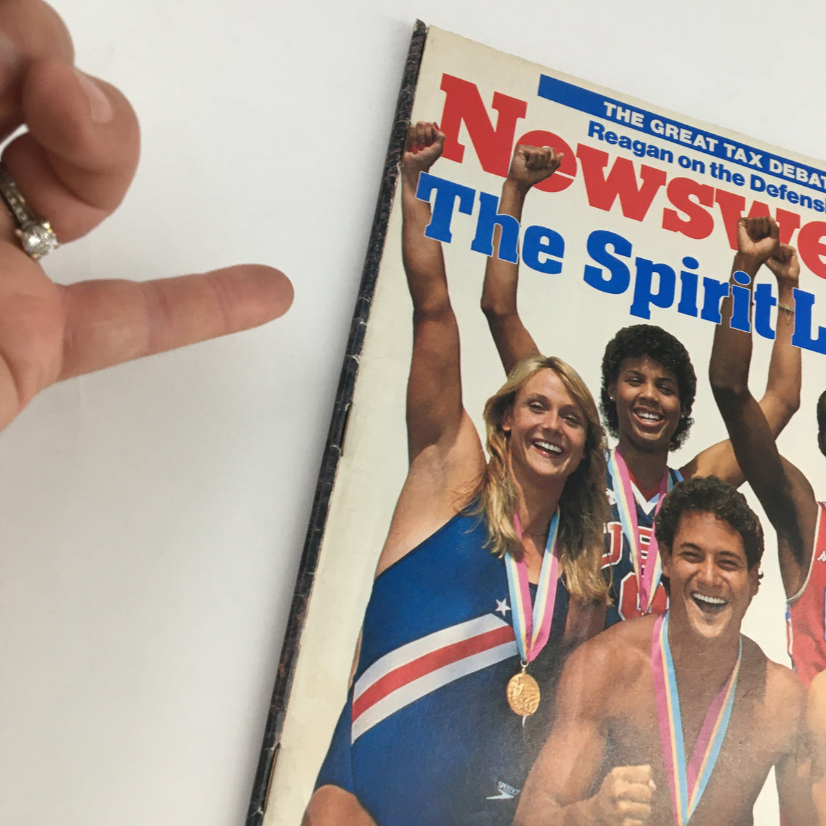 Close-up view of the Newsweek Magazine August 20, 1984 cover, titled 'The Spirit Lives,' depicting athletes in victorious poses with medals, capturing the essence of competitive spirit.