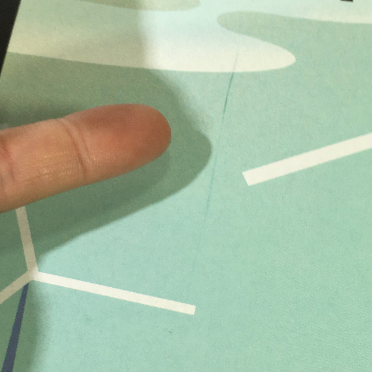 Detail view of the cover of 'The New Yorker Magazine' from May 10, 2010 featuring cover art 'Tilt' by Bob Staake with a visible finger pointing at the design.