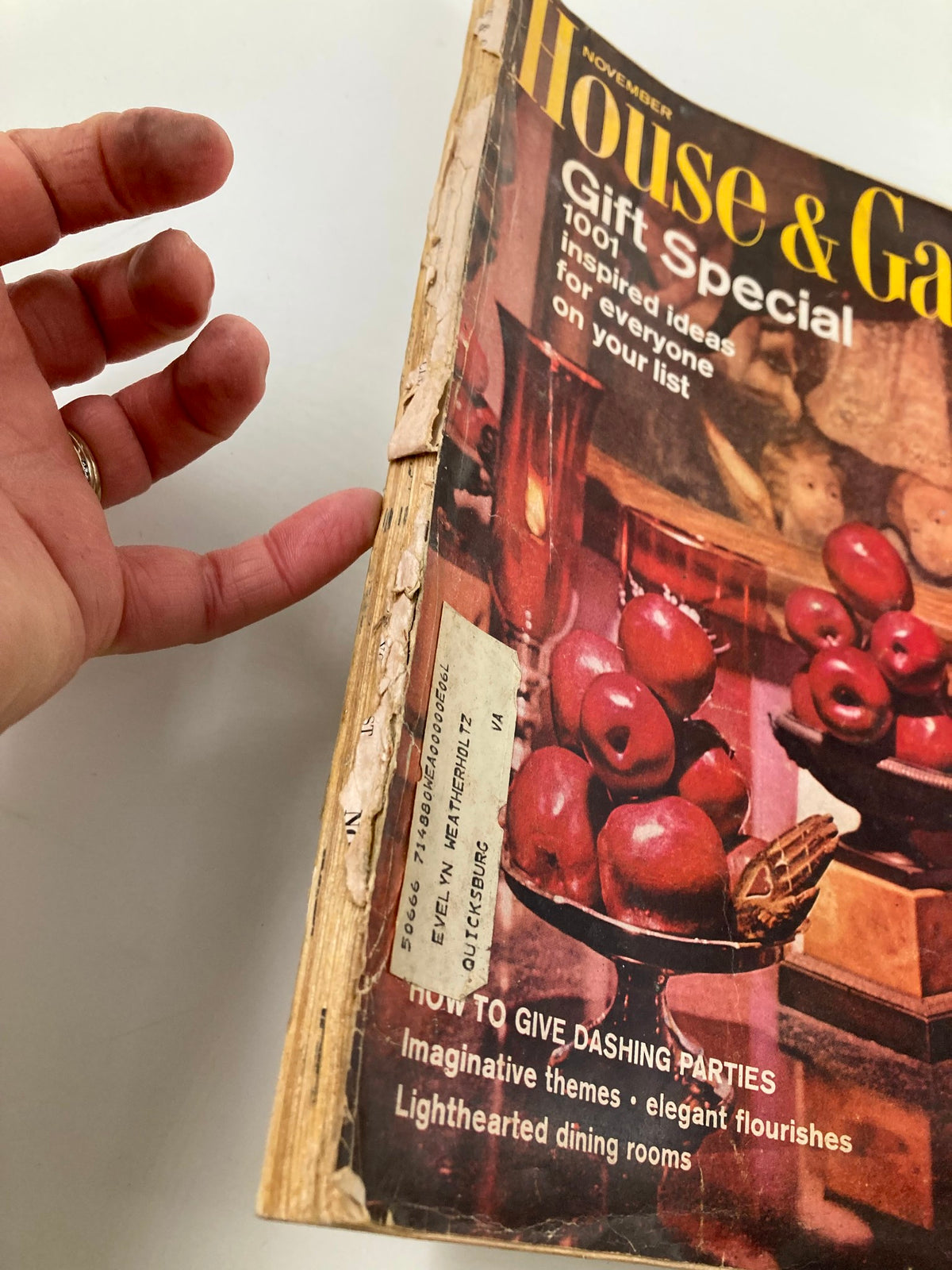 Side view of the VTG House & Garden Magazine, November 1965, showing wear and tear on the spine along with the title 'How To Give Dashing Parties'.
