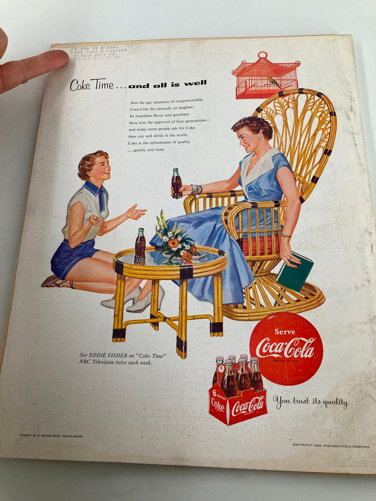 Vintage advertisement from Better Homes & Garden magazine, June 1954, featuring two women enjoying Coca-Cola in a cozy setting, reflecting the nostalgic charm and lifestyle of the 1950s.