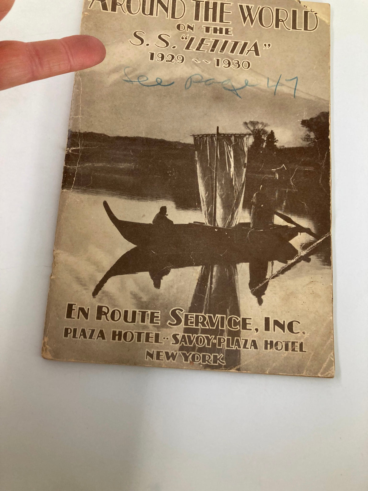 Cover detail of VTG Around The World on the S.S. Letitia 1929 - 1930 magazine with a hand pointing to a note to see page 47, depicting the vintage artwork.