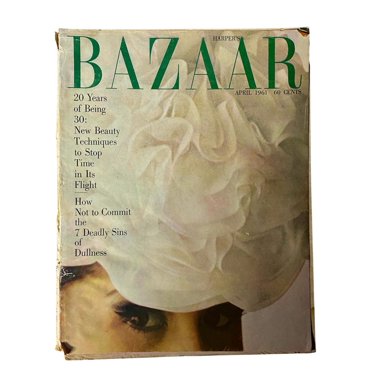 Cover of Harper's Bazaar Magazine April 1961 featuring the title 'Under All: Blue Roses'. The magazine highlights fashion elements such as a flowered snood hat and a white organdy dress, capturing early '60s elegance.