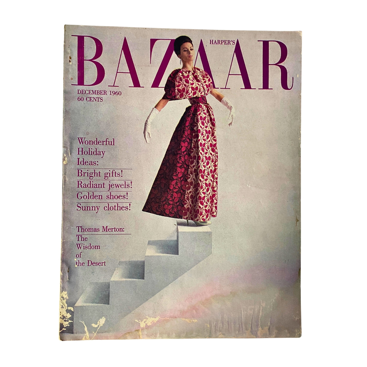 Harper's Bazaar Magazine December 1960 featuring a model in a festive gown by Mainbocher, displaying holiday elegance. The cover highlights bright gifts, radiant jewels, and golden shoes.