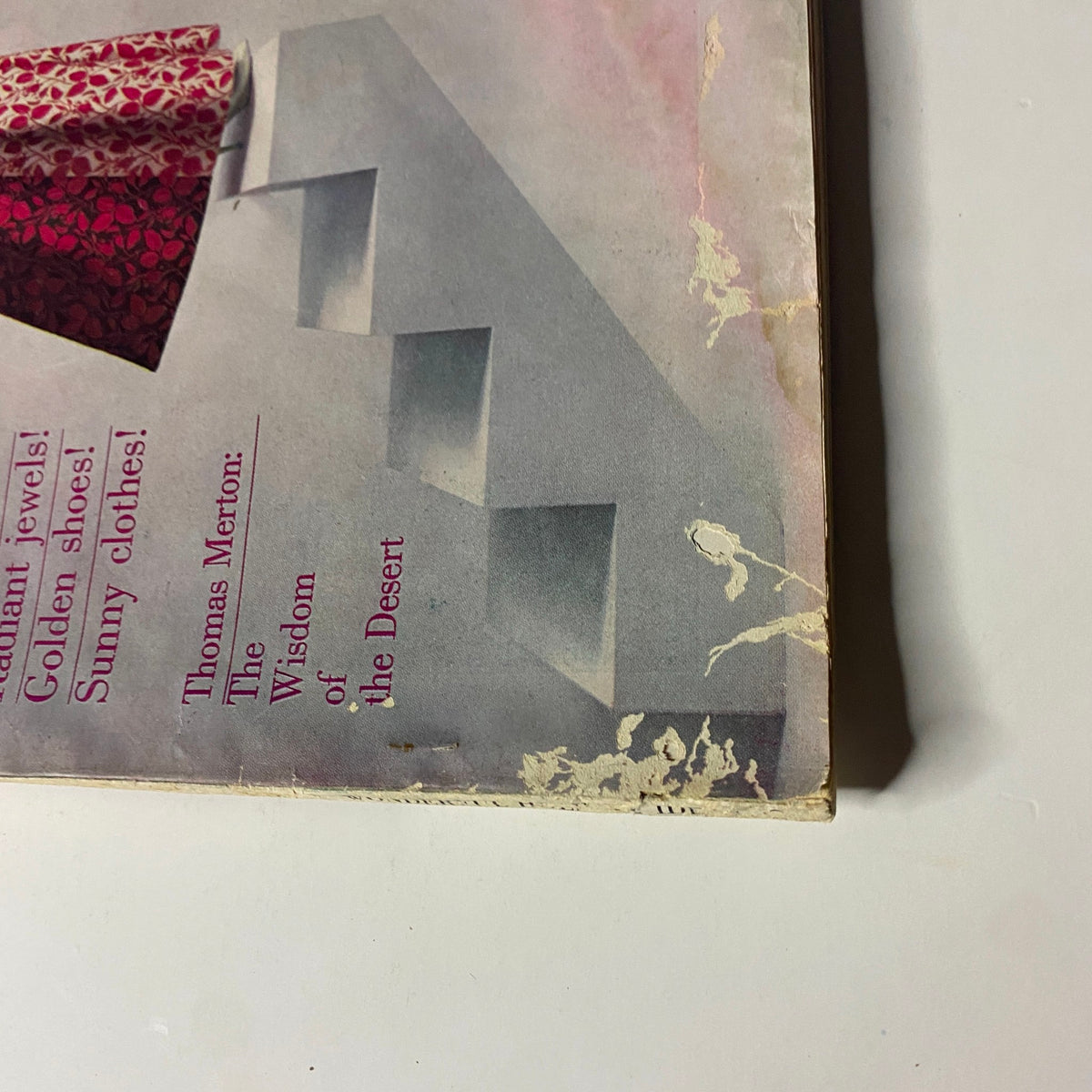 Close-up of the cover corner of Harper's Bazaar Magazine December 1960, revealing wear and tear but highlighting the model's gown and promotional text about the Thomas Merton feature.