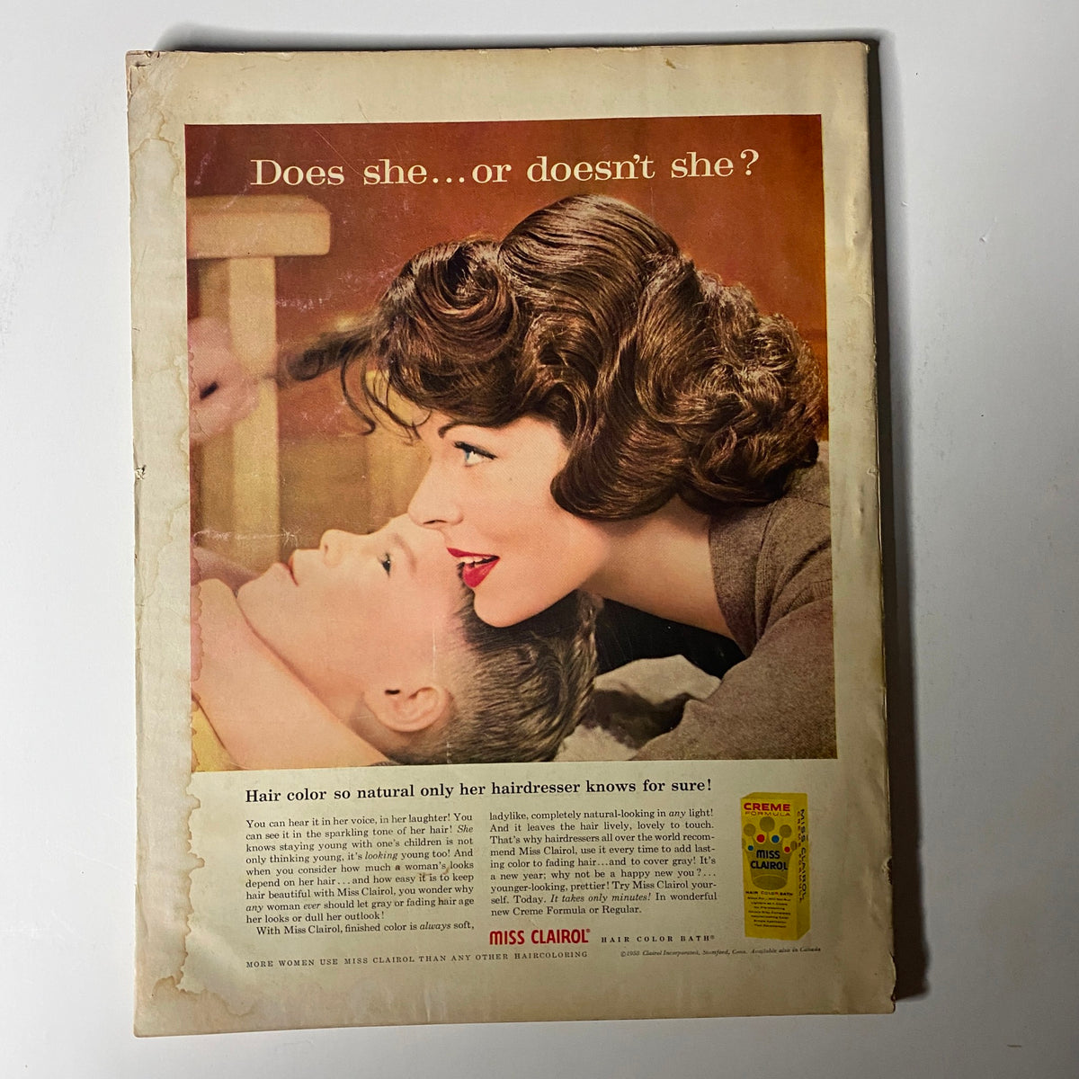 Advertisement from Harper's Bazaar Magazine January 1959 highlighting Miss Clairol hair color, depicting a woman tenderly styling a child's hair, with the tagline 'Does she...or doesn't she?' emphasizing natural beauty.