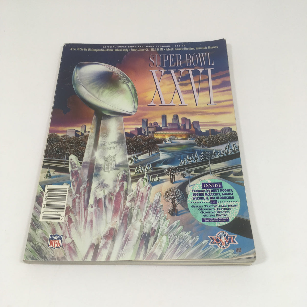 Super Bowl XXVI Game Program from January 26, 1992 featuring the Vince Lombardi Trophy with a colorful city skyline backdrop, showcasing detailed artwork and promotional highlights on the cover.