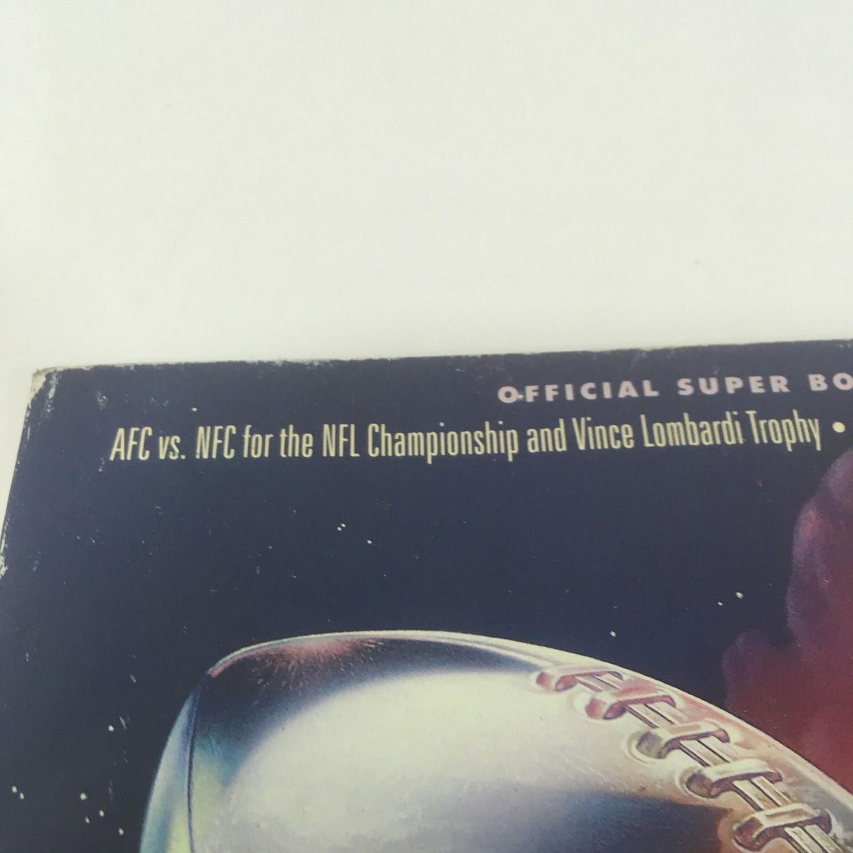 Close-up of the Super Bowl XXVI Game Program from January 26, 1992, showing the text 'AFC vs. NFC for the NFL Championship and Vince Lombardi Trophy'.