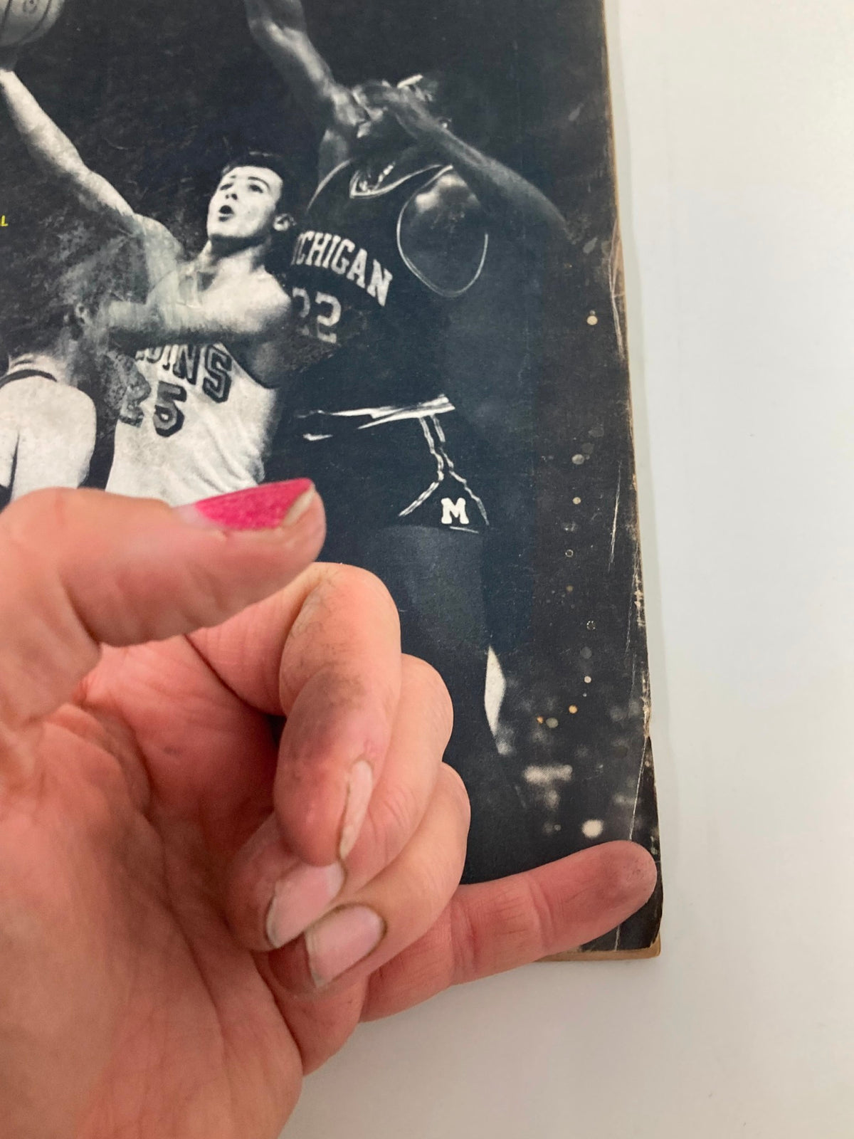 Close-up view of the front cover of the Sports Illustrated magazine from March 29, 1965, highlighting the title 'How UCLA Won Again' and capturing the action of Gail Goodrich playing against Michigan.
