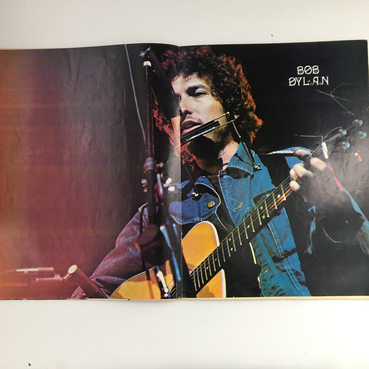 Bob Dylan performing with a harmonica and guitar, featured in Hit Parader Magazine September 1972, representing the influential music of the 70s.