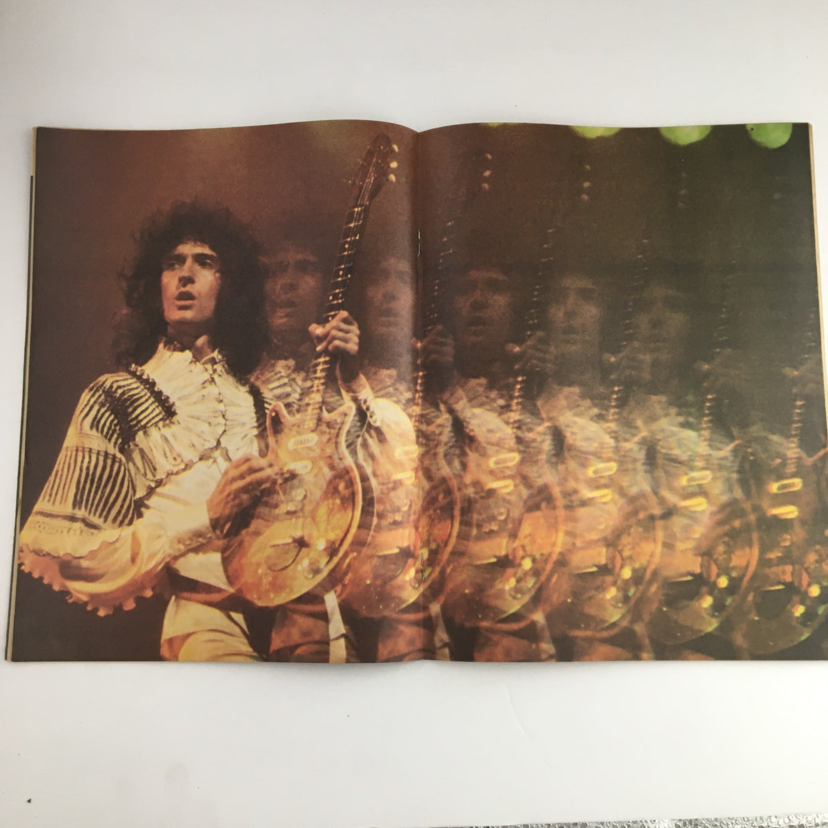 Double page spread from Hit Parader Magazine June 1977, capturing guitarist Brian May in dynamic performance, a true testament to Queen's stage presence.