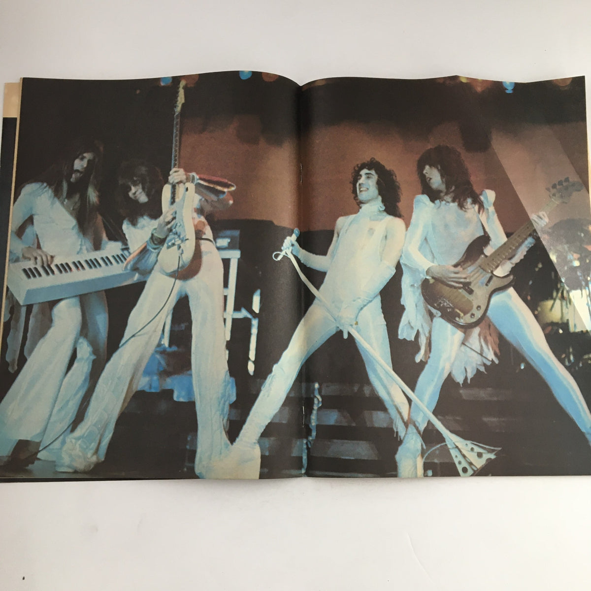 Interior spread of Hit Parader Magazine August 1977 featuring a performance by iconic rock band in white outfits, showcasing Peter Gabriel, Led Zeppelin, and Fleetwood Mac.