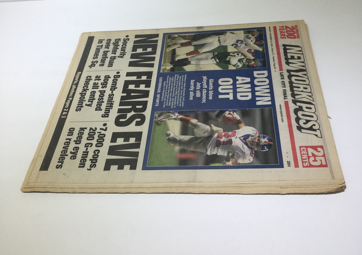 Close-up view of the New York Post front page from 12/31/2001 featuring the headline 'Down and Out' emphasizing security and sports coverage related to New Year's Eve preparations.