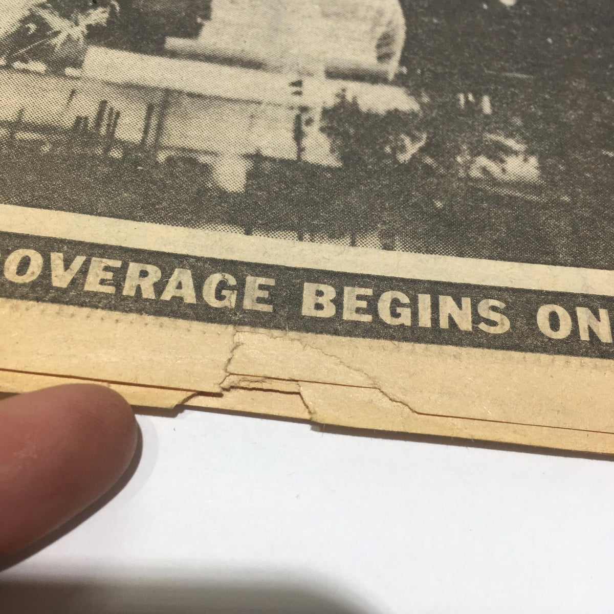 Close-up of the bottom edge of the July 4, 1986 Ny Daily News showcasing some wear and tear, with the phrase 'coverage begins on page 2' visible.
