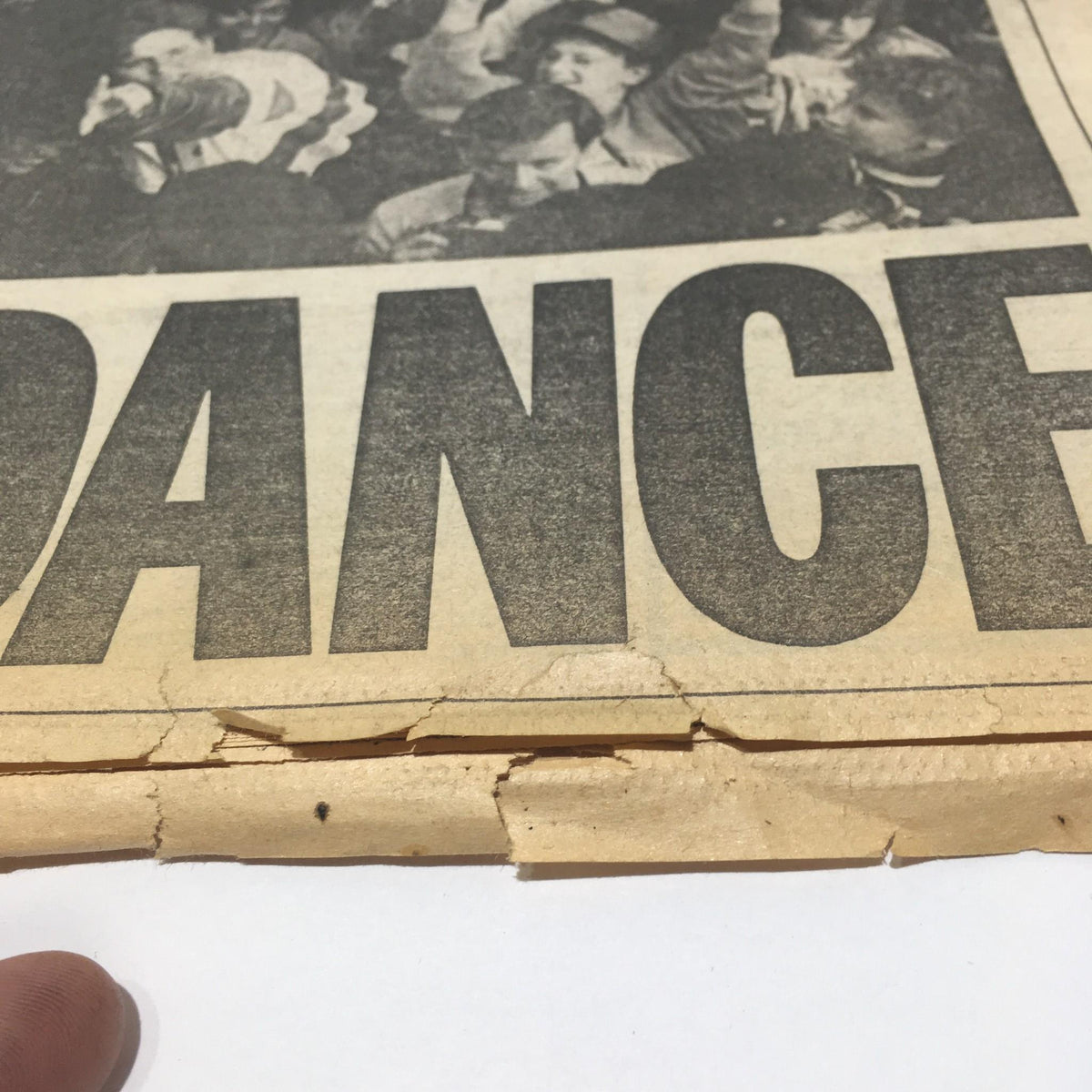 Close-up of a page from the October 29, 1986 New York Daily News showing the words 'DANCE' with some wear and tear evident on the edges.