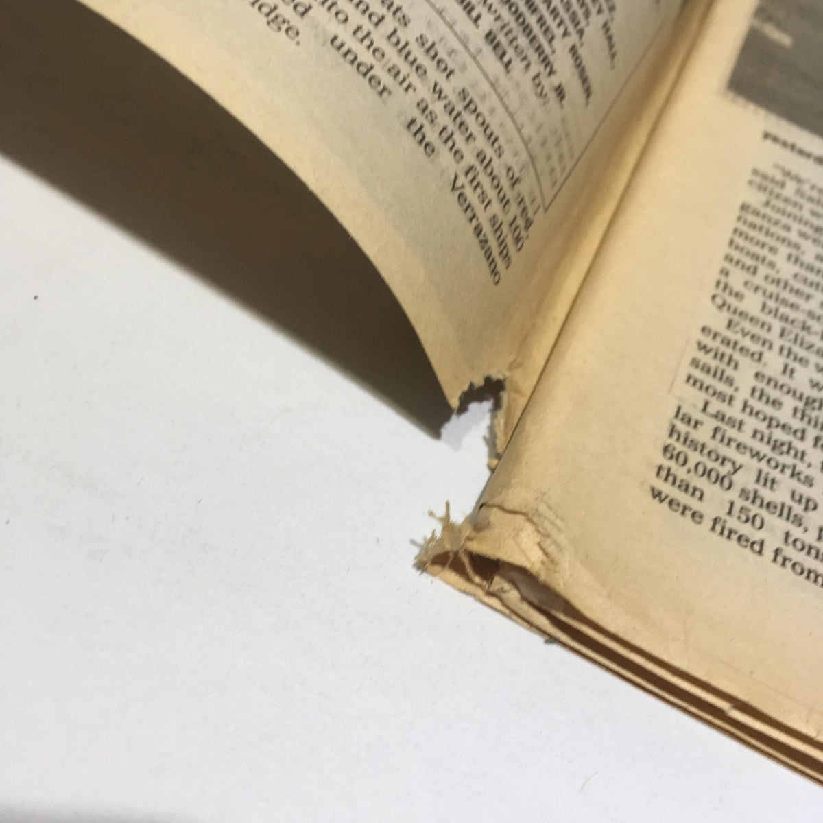 Close-up of a torn page corner from the New York Daily News, indicating age and condition of the March 16, 1991 issue.