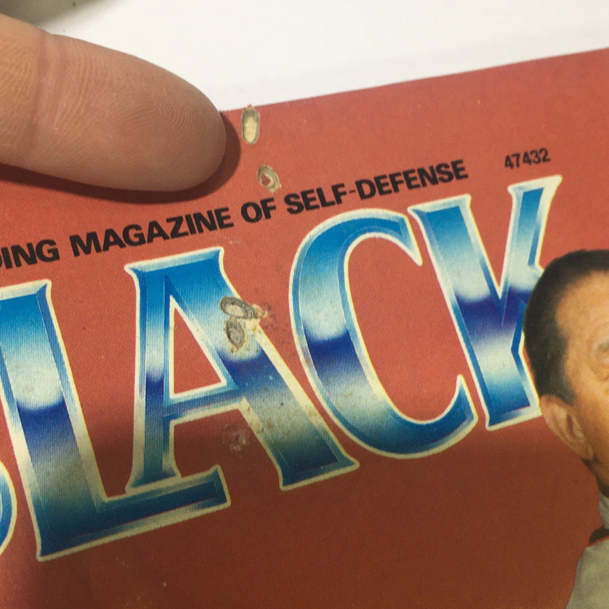 Close-up of the top left corner of VTG Black Belt Magazine May 1988 showing wear, including holes on the cover, typical for vintage magazines.