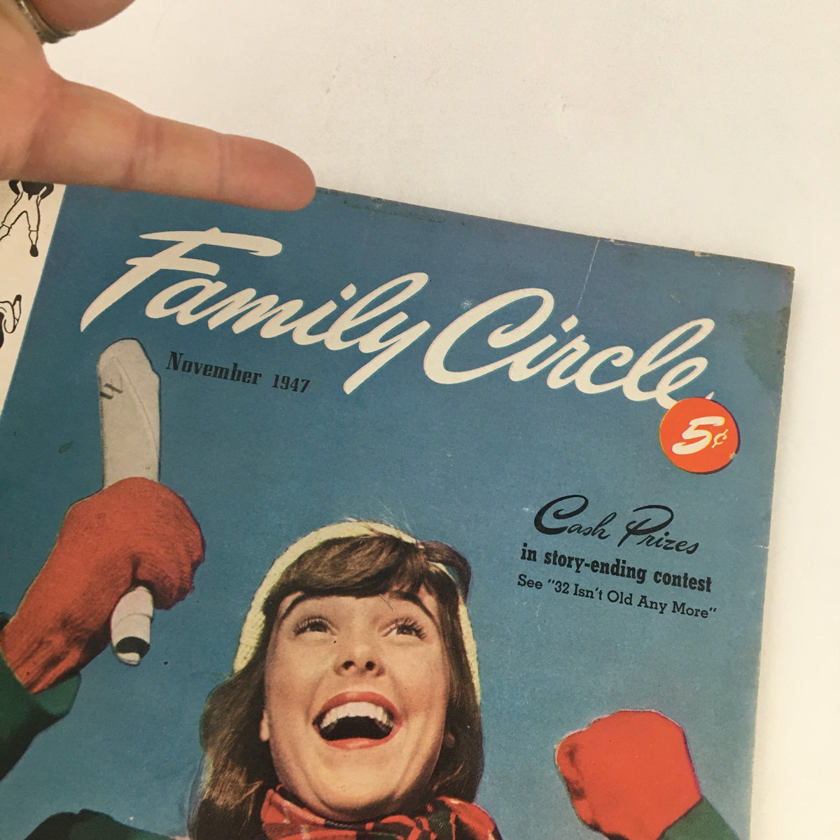 Cover of Family Circle Magazine November 1947 featuring a joyful woman with a raised arm, advertising a cash prize story-ending contest.