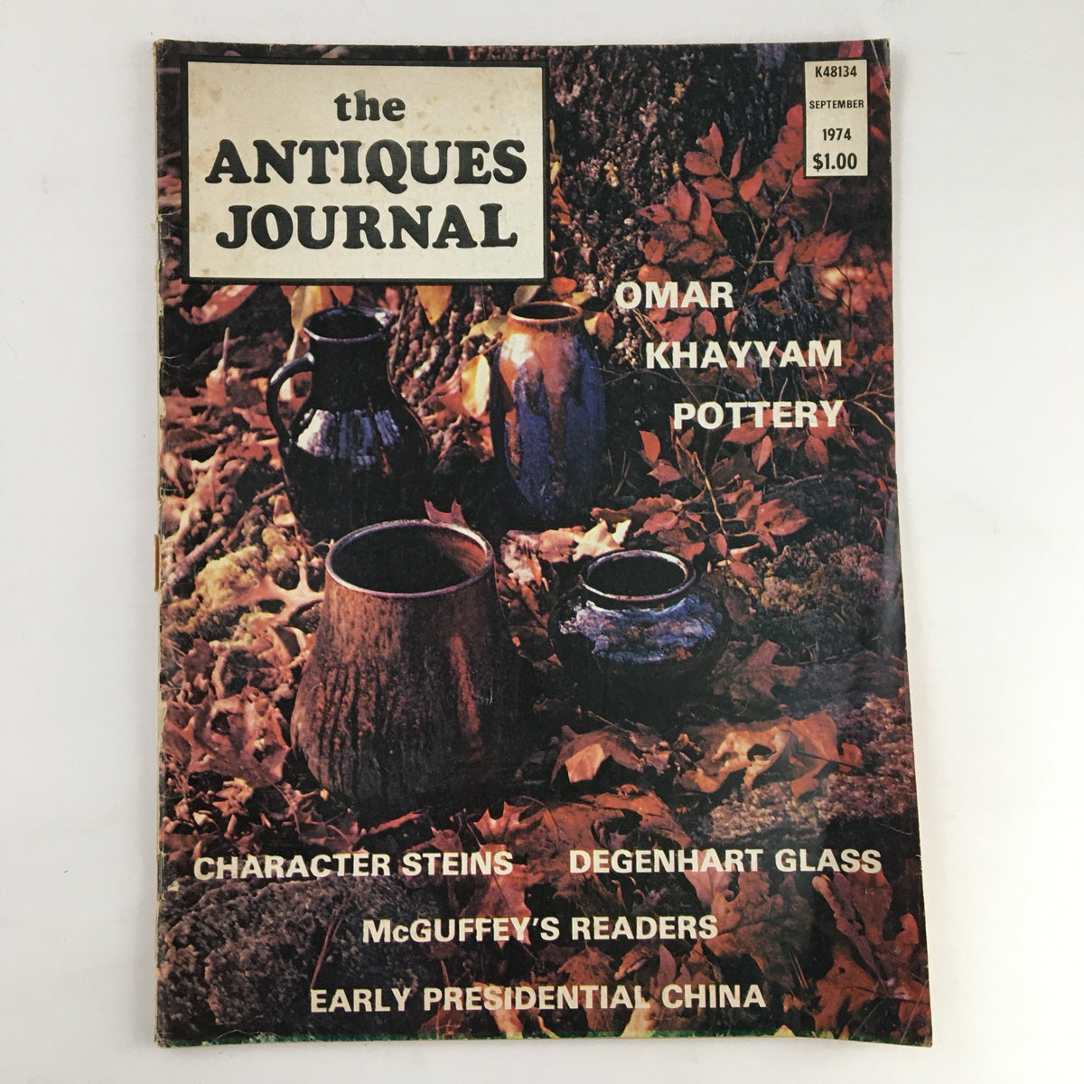 Cover of The Antiques Journal Magazine September 1974 featuring Omay Khayyam Pottery, surrounded by autumn leaves and showcasing various pottery pieces.