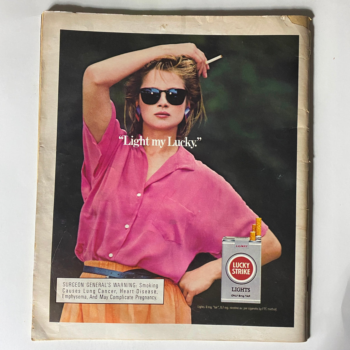 Vintage advertisement from VTG Spin Magazine August 1986 Vol 2 #5, featuring a woman in sunglasses promoting Lucky Strike cigarettes in a nostalgic setting.