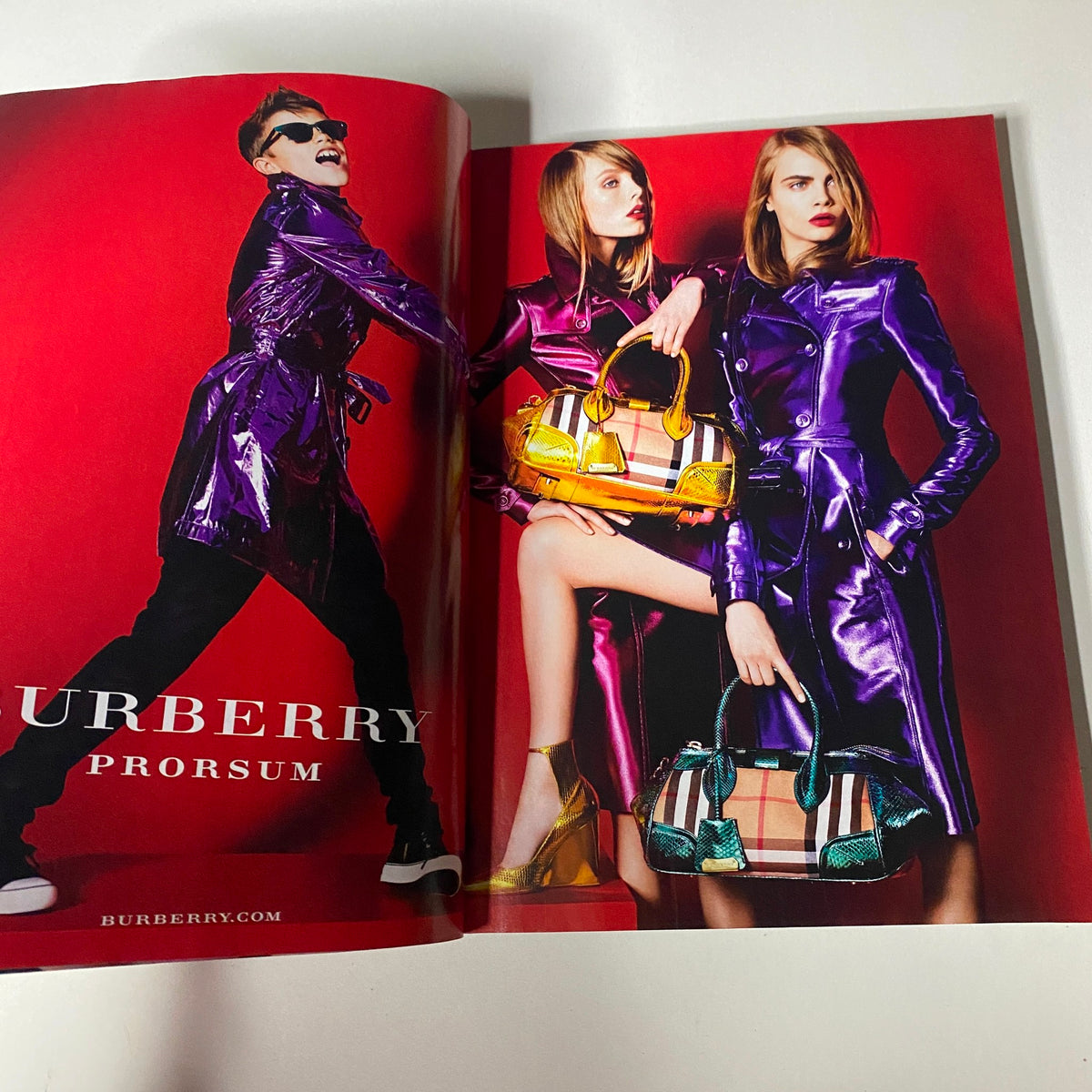 Vogue Magazine April 2013 Michelle Obama Cover No Label highlighting a Burberry advertisement featuring models in vibrant purple coats displaying stylish handbags.