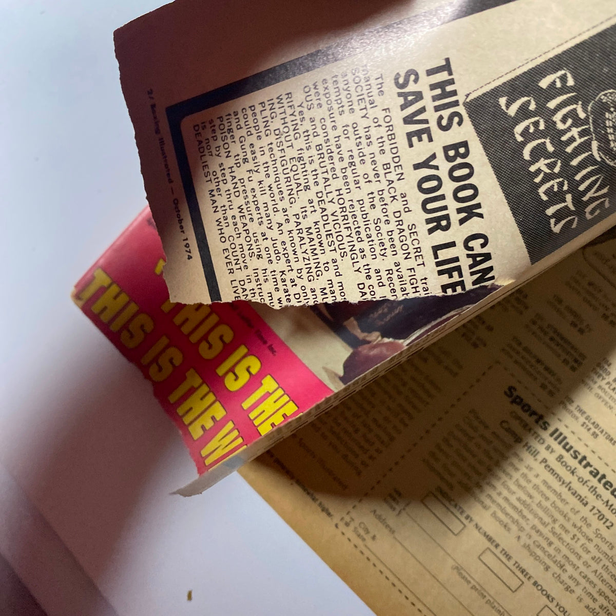Inside Boxing Illustrated Magazine October 1974 showing a torn advertisement with the text 'THIS BOOK CAN SAVE YOUR LIFE' highlighting the vintage magazine's contents.