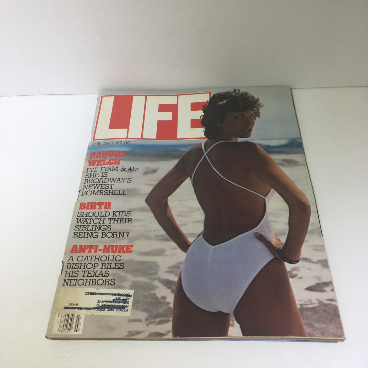 Cover of Life Magazine featuring Raquel Welch for July 1982, showcasing her in a one-piece swimsuit by the beach.