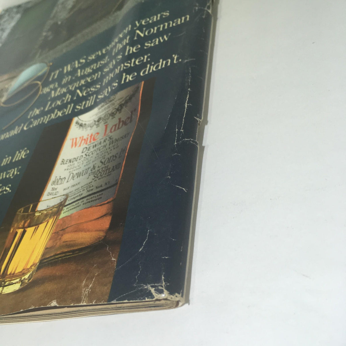 Detailed view of the back cover of Life Magazine, revealing wear and advertising for Dewar's whisky.