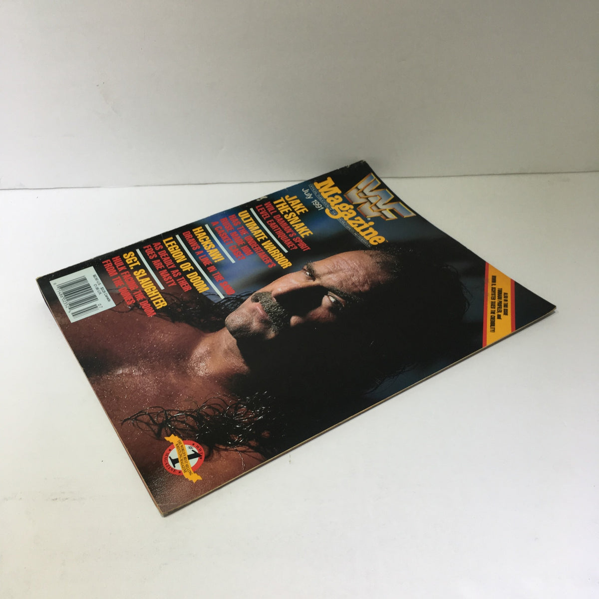 WWF Magazine July 1991 featuring Jake the Snake on the cover, showcasing bold colors and text.