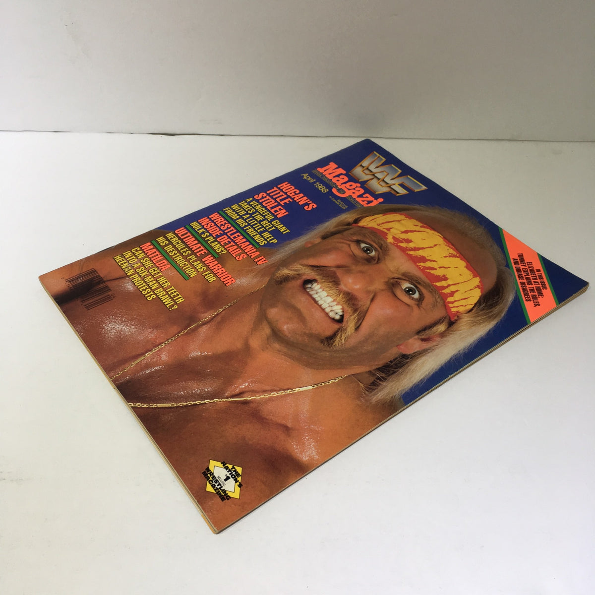 Cover of WWF Magazine: Hogan's Title Stolen - Wrestle Mania IV Inside Details, April 1988. Features a dynamic image of a muscular wrestler with a prominent mustache, wearing a red and yellow bandana and showcasing an intense expression, emphasizing the excitement of wrestling history.