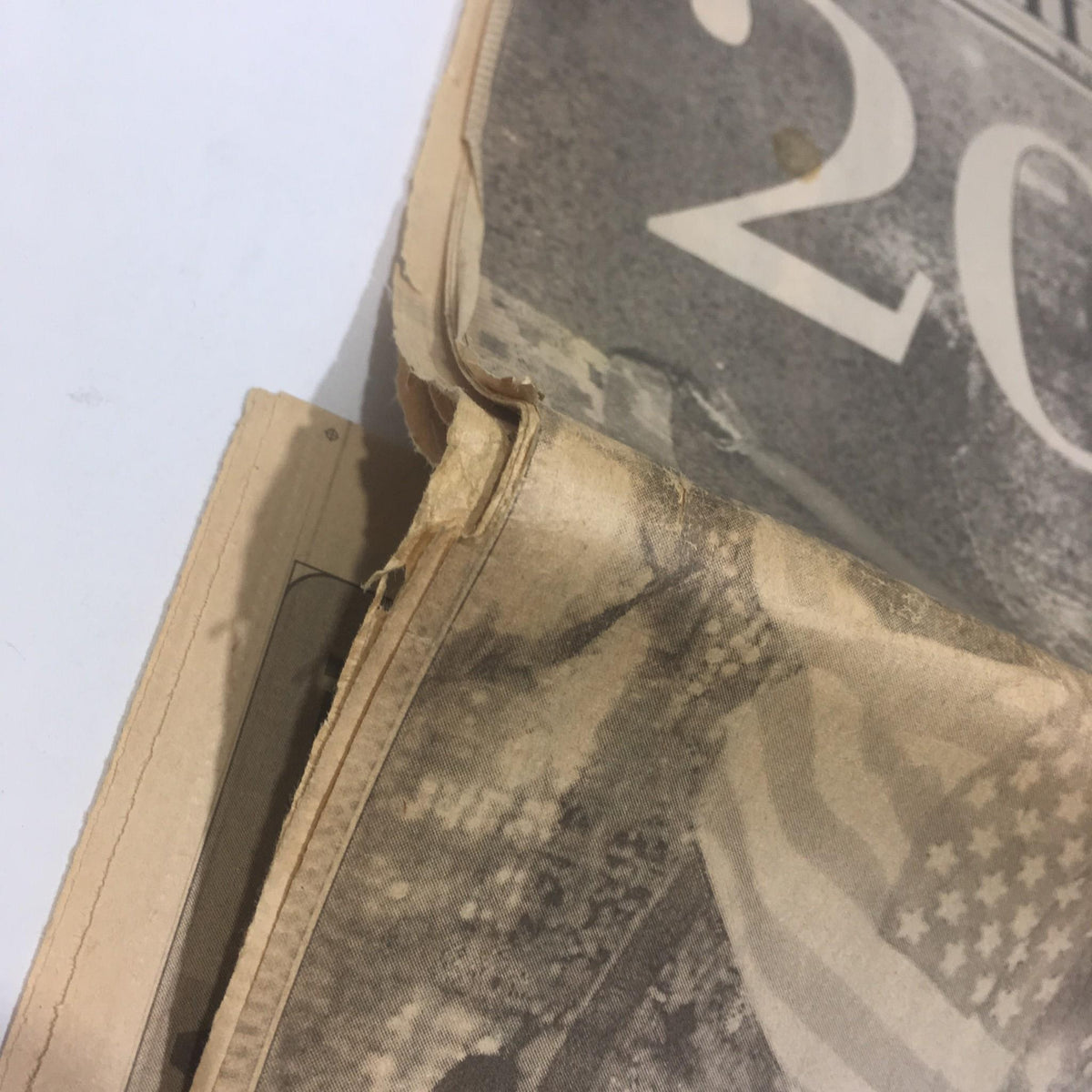 Close-up view of the NY Daily News newspaper from 1/1/2000, showing the corner of the page with wear, commemorating the largest peacetime crowd in Times Square.
