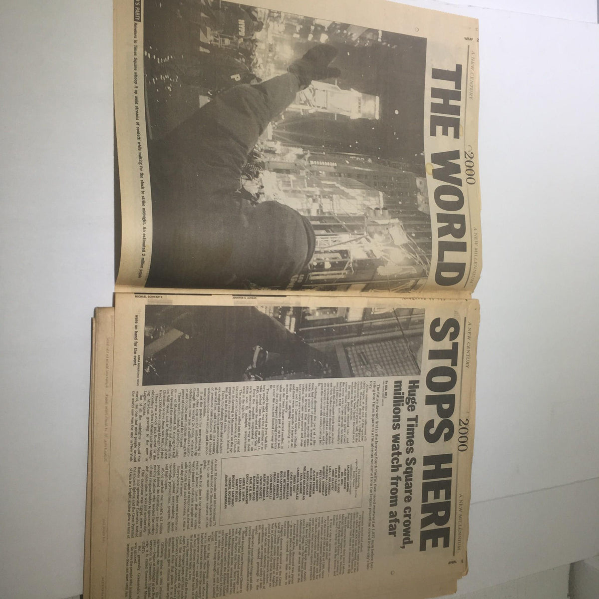 Open newspaper page from the NY Daily News dated 1/1/2000, displaying images and headlines about the New Millennium celebration, marking the largest peacetime crowd in Times Square.